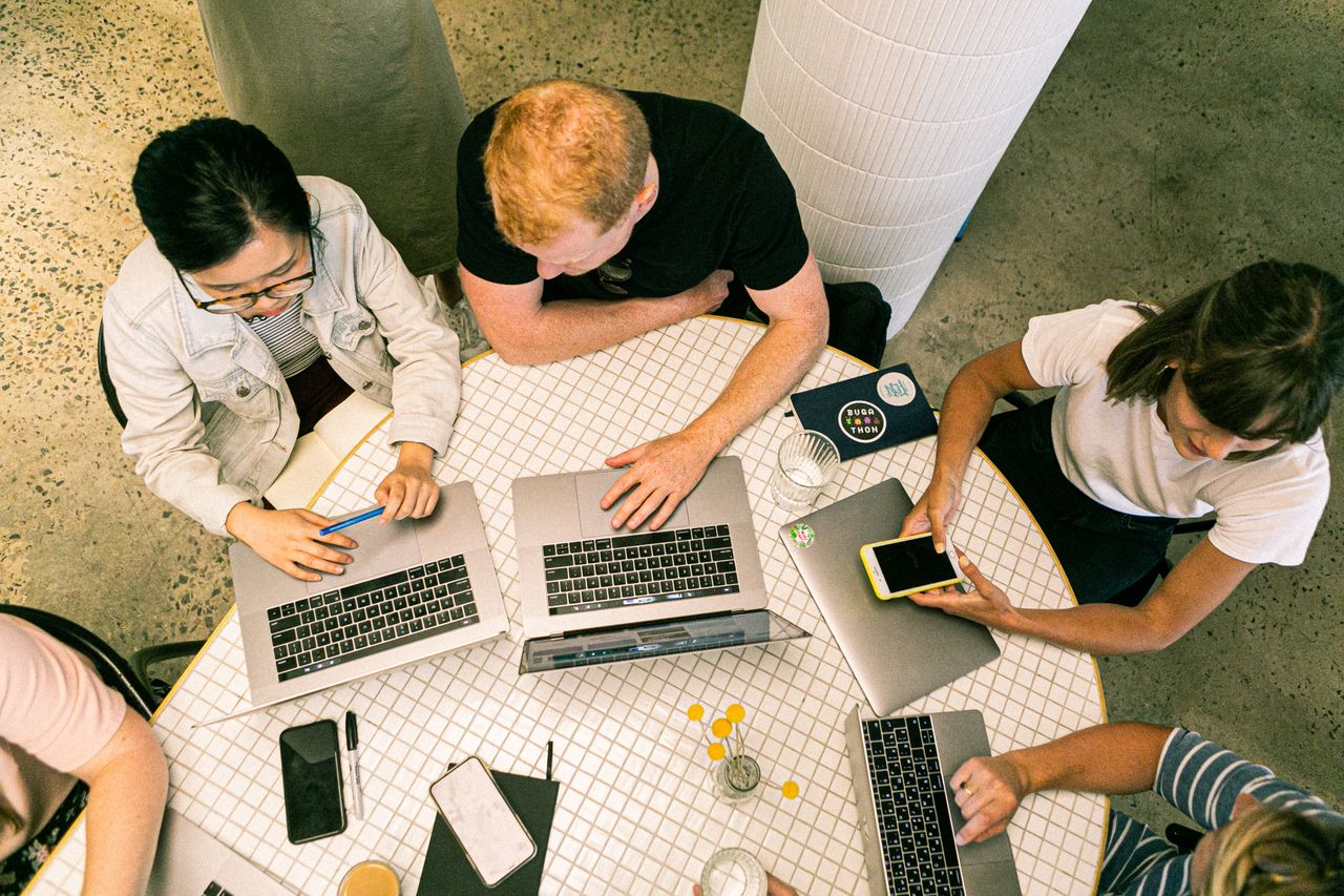 Services Top view of diverse team collaboratively working in a modern office setting.