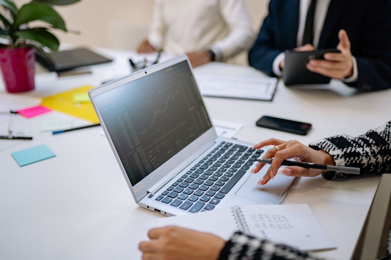 About Professionals analyze financial data on laptop during office meeting.